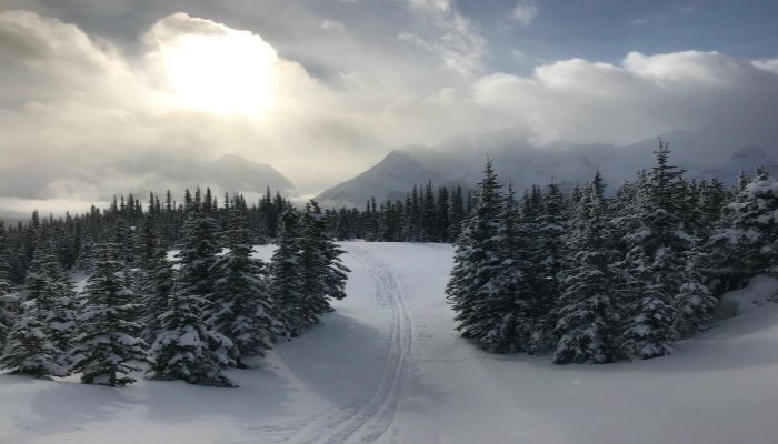 A photo of a moody, cloudy, sunny sky from Kananaskis Fire Lookout, Alberta, Canada, a great place to know how to make a decision if you can't decide.